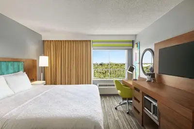 a hotel room with a bed and a television at Hampton Inn & Suites Fort Lauderdale Airport in Hollywood
