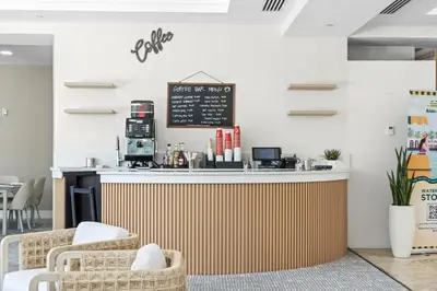 a coffee shop with a counter and chairs at GALLERY One - A DoubleTree Suites by Hilton Hotel in Fort Lauderdale