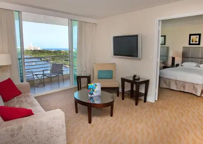 a hotel room with a bed and a living room at GALLERY One - A DoubleTree Suites by Hilton Hotel in Fort Lauderdale