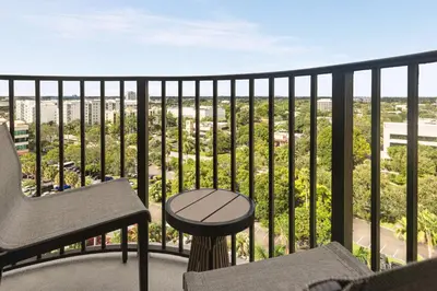 a balcony with a chair and a table at Embassy Suites by Hilton Fort Lauderdale 17th Street in Fort Lauderdale