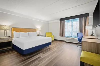 a hotel room with a bed and a desk at La Quinta by Wyndham Miami Airport West in Miami