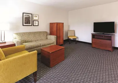 a living room with a couch and a flat screen tv at La Quinta by Wyndham Miami Airport East in Miami
