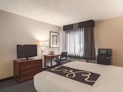 a hotel room with a bed and a flat screen tv at La Quinta by Wyndham Miami Airport East in Miami