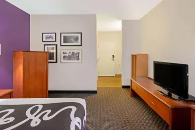 a hotel room with a bed and a flat screen tv at La Quinta by Wyndham Miami Airport East in Miami