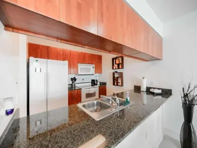 a kitchen with a sink and a refrigerator at Beautiful Apartment in the Heart of Brickell in Miami