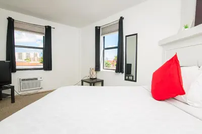 a white bedroom with a red pillow on a bed at Apartments in the Heart of Miami - Port of Miami / Miami Airport in Miami