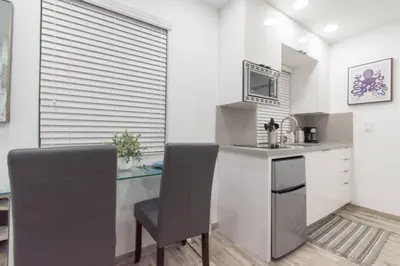 a kitchen with a desk and a table and chairs at Renovated studio wocean view boardwalk steps in Hollywood