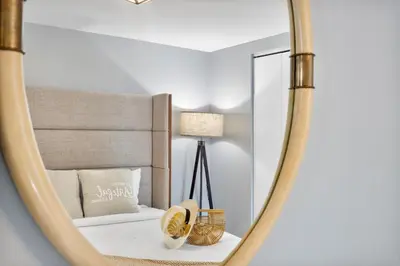 a mirror in a bedroom with a bed and a lamp at Marvelous apartment in Brickell in Miami