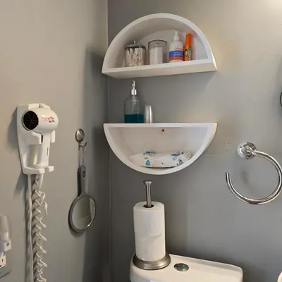 a bathroom with a toilet with a shelf above it at Suite Life at Chez Mercedes in Miami