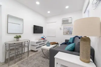 a living room with a couch and a table at Modern studio wqueen bed beach views in Hollywood