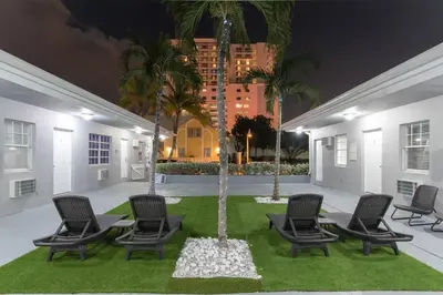 a group of chairs and palm trees in a courtyard at Modern studio wqueen bed beach views in Hollywood