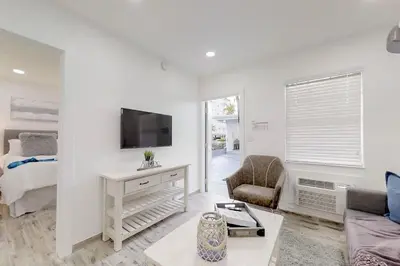 a white living room with a bed and a tv at Modern apartment wking bed steps to beach in Hollywood