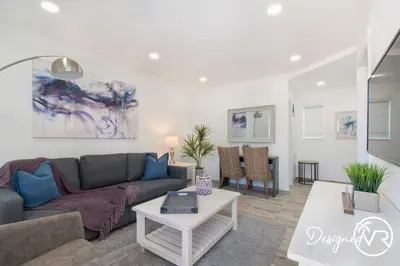 a living room with a couch and a table at Modern apartment wking bed steps to beach in Hollywood
