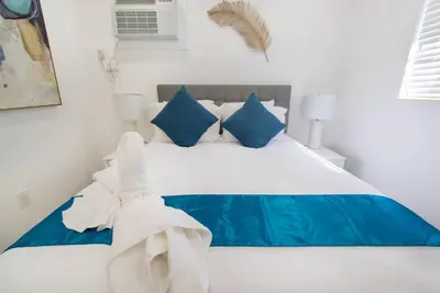 a bedroom with a bed with blue and white pillows at Modern apartment wbeach steps parking in Hollywood