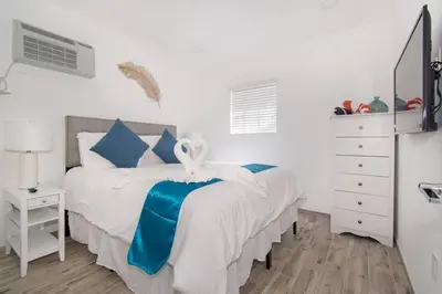 a bedroom with two beds with blue and white sheets at Modern apartment wbeach steps parking in Hollywood