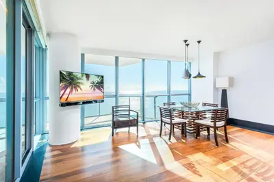 a dining room with a table and a television at Oceanfront Private Condo at The Setai -2707 in Miami Beach
