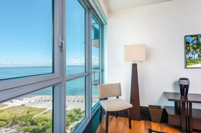 a room with a desk and window view of the beach at Oceanfront Private Condo at The Setai -2707 in Miami Beach