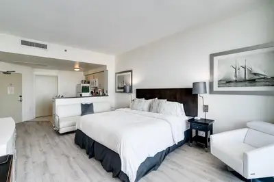 a bedroom with a large white bed and a couch at City View Balcony steps from Restaurants, Peacock Park & Marina in Miami