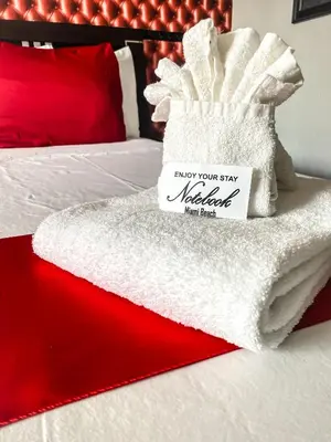 a bed with a pile of towels on it at Notebook Miami Beach in Miami Beach