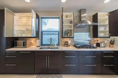 a kitchen with black cabinets and a sink and a window at Spacious 5BR home w heated pool fire pit in Hollywood