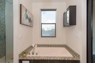 a bath tub in a bathroom with a window at Spacious 5BR home w heated pool fire pit in Hollywood