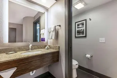 a bathroom with a sink and a toilet and a mirror at Sleep Inn Miami Airport in Miami