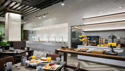 a restaurant with tables and a counter with food at DoubleTree by Hilton Hotel Miami Airport & Convention Center in Miami