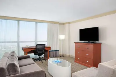 a living room with a couch and a desk and a television at DoubleTree by Hilton Hotel Miami Airport & Convention Center in Miami