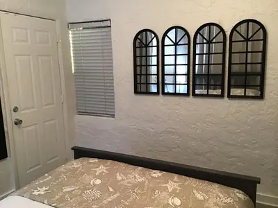 a bedroom with three mirrors above a bed at Modern 3/1 house close to Beaches and Midtown in Miami