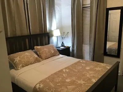 a bedroom with a bed and a mirror in a room at Modern 3/1 house close to Beaches and Midtown in Miami