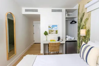 a bedroom with a bed and a desk with a chair at Casa Ocean in Miami Beach