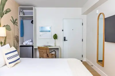 a bedroom with a white bed and a desk at Casa Ocean in Miami Beach
