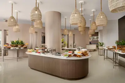 a restaurant with food on a counter with pendant lights at Trump International Beach Resort - Sunny Isles Beach in Miami Beach