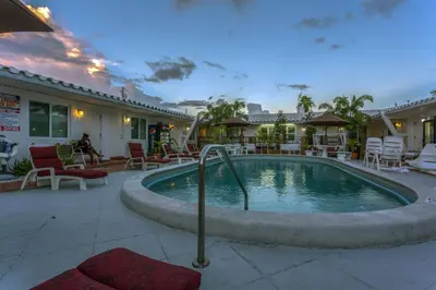 a pool in a patio with chairs and tables at Green Seas Motel in Hollywood