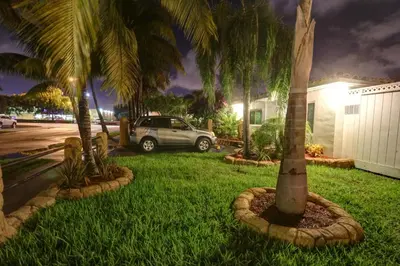 a car parked in a yard with palm trees at Green Seas Motel in Hollywood