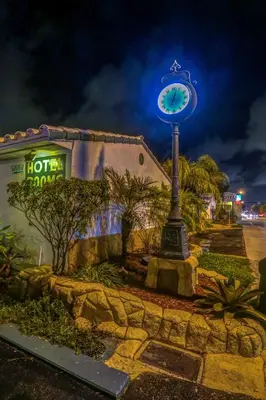 a clock on a pole in front of a building at Green Seas Motel in Hollywood