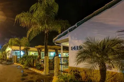 a resort with palm trees in front of a building at Green Seas Motel in Hollywood