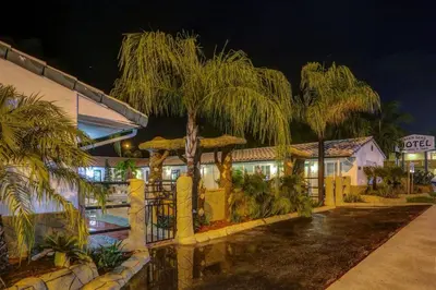 a hotel at night with palm trees in front of it at Green Seas Motel in Hollywood
