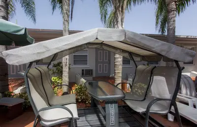 a table and chairs under an umbrella on a patio at Richard's Motel Extended Stay in Hallandale Beach