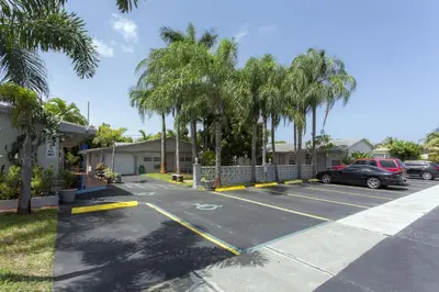 a car parked in a parking lot with palm trees at Richard's Motel Extended Stay in Hallandale Beach