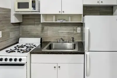 a white kitchen with a sink and a stove at Richard's Motel Extended Stay in Hallandale Beach