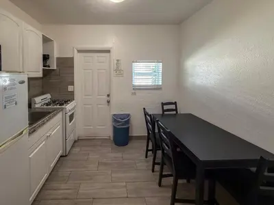 a kitchen with a table and a table and chairs at Richard's Motel Extended Stay in Hallandale Beach