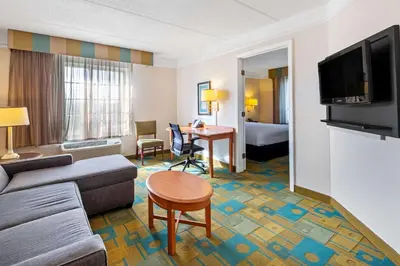 a living room with a couch and a table in a hotel room at La Quinta by Wyndham Ft. Lauderdale Plantation in Plantation