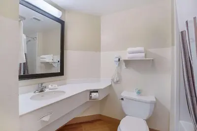 a bathroom with a sink and a toilet and a mirror at La Quinta by Wyndham Ft. Lauderdale Airport in Hollywood