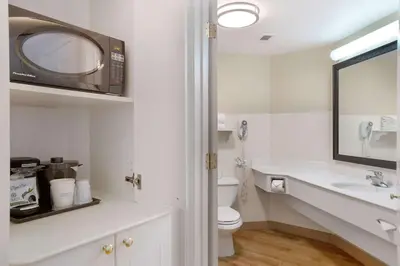 a bathroom with a toilet and a sink and a microwave at La Quinta by Wyndham Ft. Lauderdale Airport in Hollywood