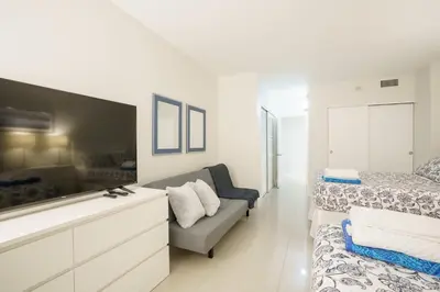 a white bedroom with a bed and a couch in it at Ocean Reserve 14th floor - Wonderful Ocean View - STR00454 in Miami Beach