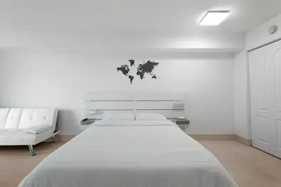 a white bedroom with a large bed and a white couch at Centric Modern, Stylish Brickell / Miami + FREE Parking in Miami