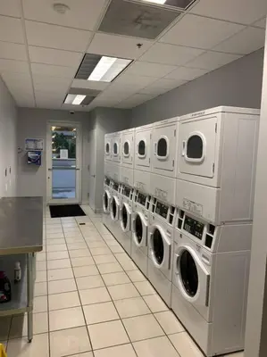 a laundry room with a row of washers and dryers at Centric Modern, Stylish Brickell / Miami + FREE Parking in Miami