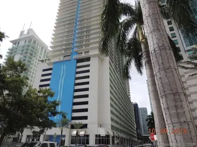 a tall white building with a blue stripe on it at Centric Modern, Stylish Brickell / Miami + FREE Parking in Miami