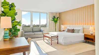 a bedroom with a bed and a living room at 1100 West South Beach Luxe Miami Condos by Joe Semary in Miami Beach